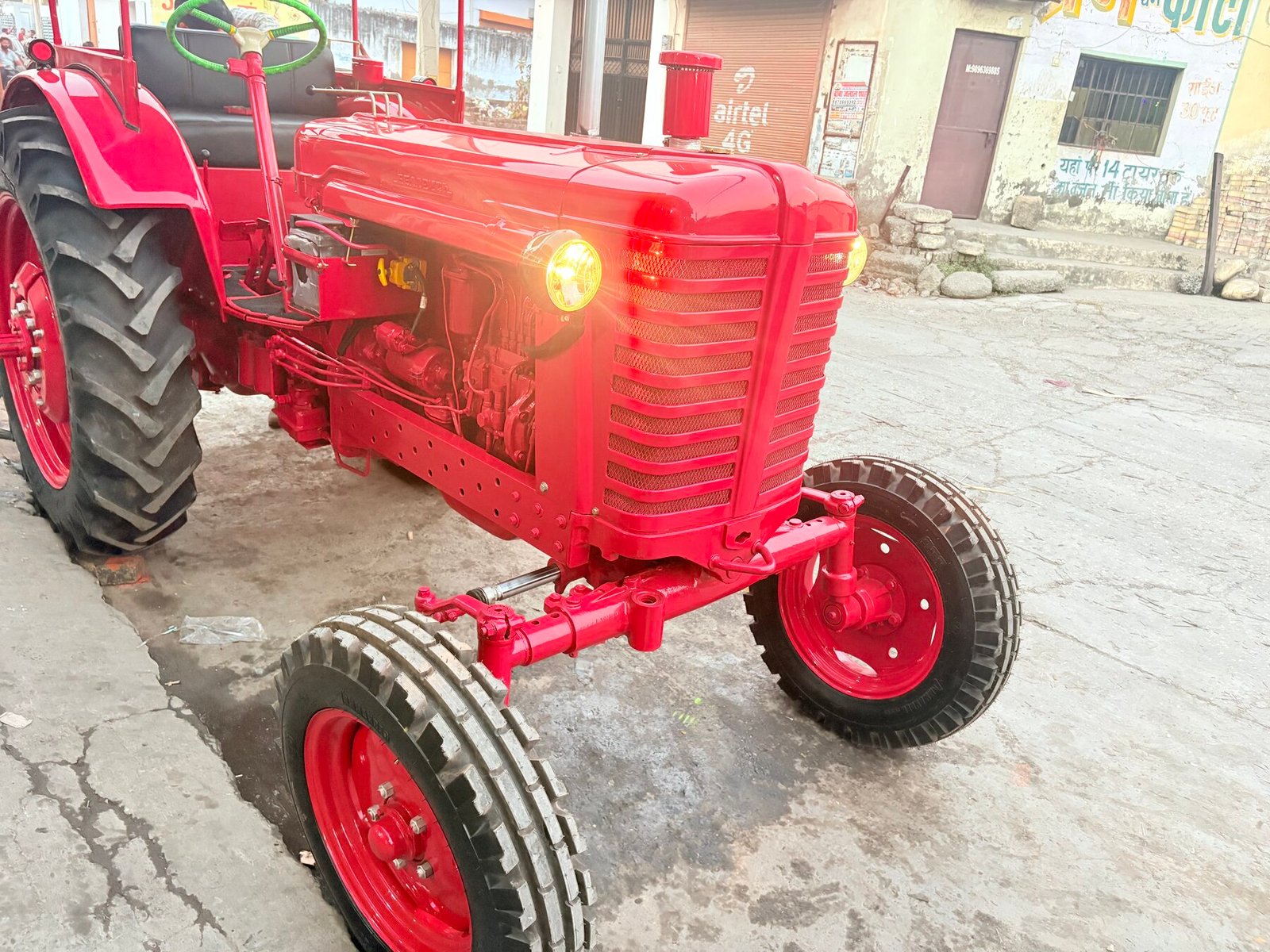 Restored red Belarus tractor, headlight running